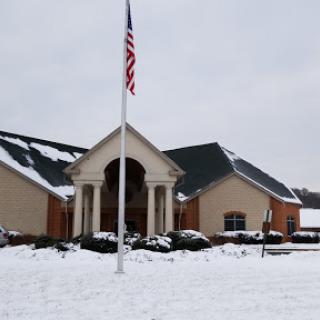 A snow-covered building with a flag in front, showcasing winter scenery.