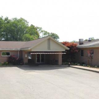 The image shows the exterior of a brick building with a prominent entrance.
