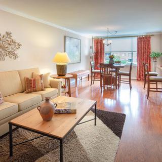 A modern living room with an adjoining dining area, featuring cozy furniture and stylish decor.