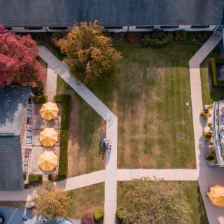 Aerial view of a courtyard with intersecting pathways, outdoor seating, and trees.