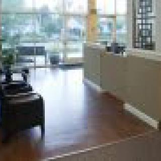 A brightly lit office reception area with chairs and a desk.
