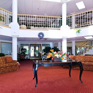 A spacious lobby with elegant furniture and a central table adorned with flowers.
