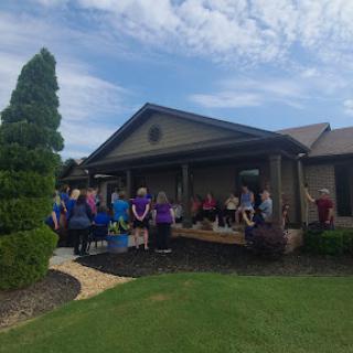 A community gathering outside a house on a sunny day.