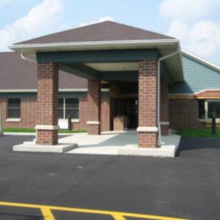 A building entrance with a covered walkway and brick columns.