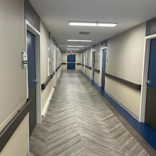 A well-lit corridor featuring multiple doors and modern flooring design.