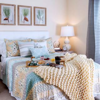 A cozy, well-decorated bedroom with a neatly made bed and soft lighting.