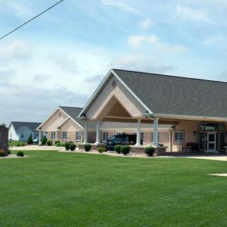 A suburban building with a large lawn and clear sky.
