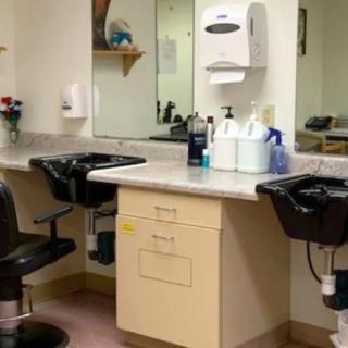 A hair salon setup featuring mirrors, chairs, and washing stations.