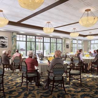 A dining area with several seniors seated at tables, featuring elegant chandeliers and large windows allowing natural light.