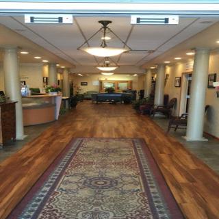 A spacious and well-lit lobby area with a reception desk and comfortable seating.