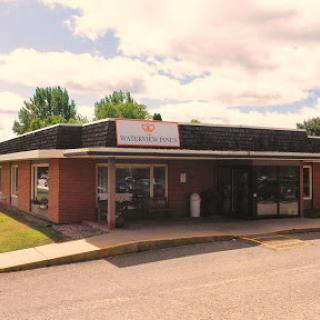 A retail store with a welcoming facade under a partly cloudy sky.