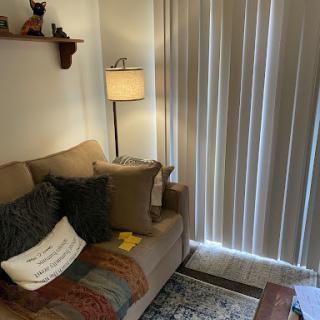 A cozy corner of a living room featuring a comfortable sofa, soft lighting, and decorative elements.