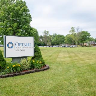 A welcoming sign for an organization set in a green, landscaped area.