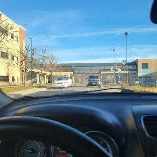 A view from inside a car approaching a building on a sunny day.