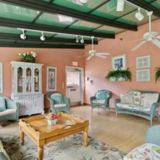 A cozy living room with pastel-colored walls, comfortable seating, and a wooden coffee table.