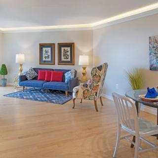 A modern living room with a blue sofa, colorful armchair, and bright decor.