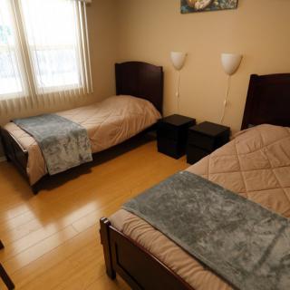 A cozy bedroom with twin beds and wooden flooring.