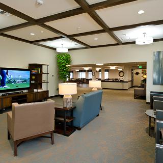 A modern lobby area with comfortable seating and a large television.