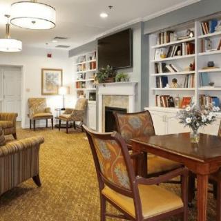 Cozy living room with bookshelves and a fireplace, featuring comfortable seating and elegant decor.