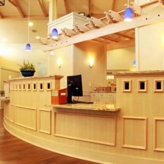 A modern reception desk area with warm lighting and a computer setup.