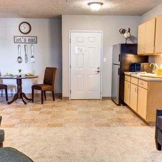 A cozy kitchen and dining area with a small table, chairs, and a fully equipped kitchen.