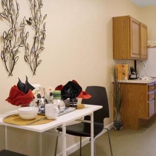 A cozy kitchen dining area with a small table, chairs, and decorative wall art.
