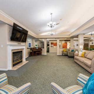 A modern living room with comfortable seating, a fireplace, and a mounted television.