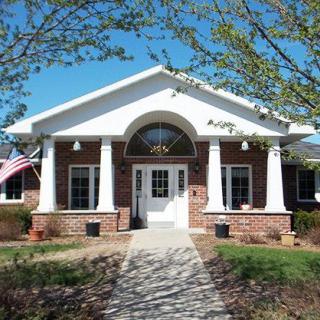 A charming house with columns, an American flag, and a path leading to the entrance.