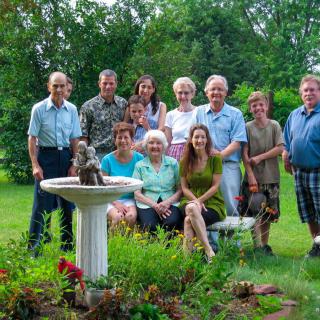 A family posing together in a garden setting on a summer day.
