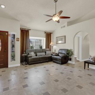 A spacious living room with modern furniture and tiled flooring.