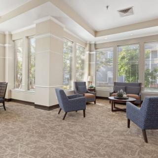 A bright and inviting lounge area with blue chairs and large windows.