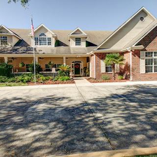 A large suburban residential building with a driveway in front.