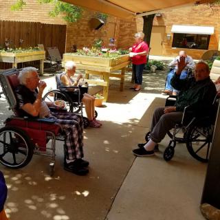 A group of seniors socializing outdoors in a recreational area.