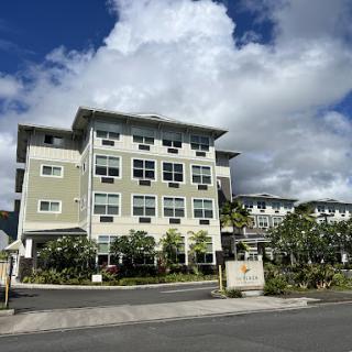 A modern residential building under a partly cloudy sky.