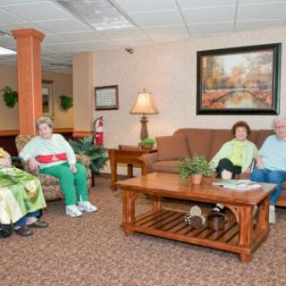 A group of seniors sitting in a comfortable lounge area of a retirement home.