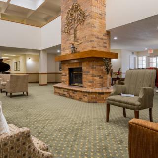 A cozy lounge area with a central brick fireplace and comfortable seating.