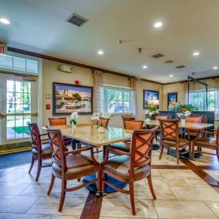 A well-lit dining area with multiple tables and chairs arranged neatly.