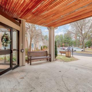 Outdoor building entrance with a wooden canopy and benches.
