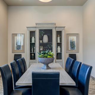 A stylish dining room featuring a modern table, dark chairs, and elegant decor.