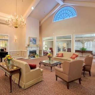 A cozy and elegant living room with comfortable seating, a fireplace, and a chandelier.