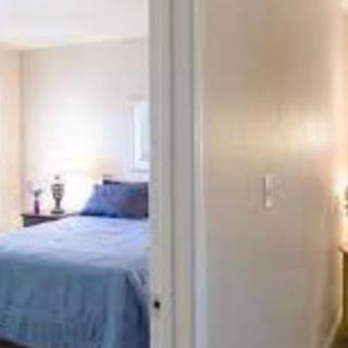 A cozy bedroom with a neatly made bed and soft lighting.