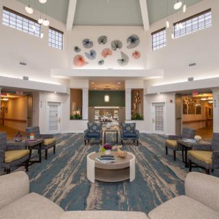 A spacious and well-lit lounge area with comfortable seating and decorative elements on the walls.
