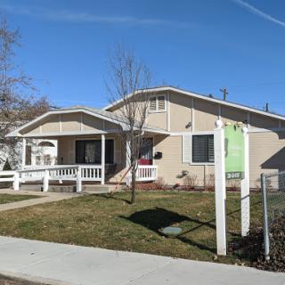 A charming single-family home with a welcoming porch and well-maintained front yard.