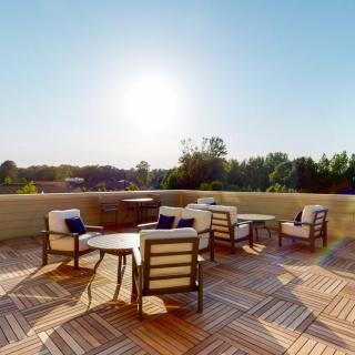 A sunny outdoor patio with comfortable seating and tables.