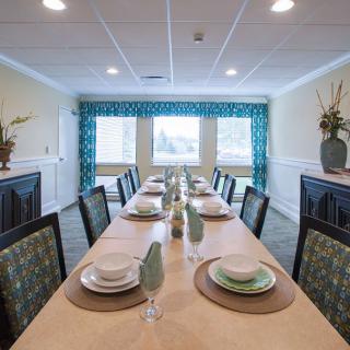 Elegantly set dining room with a long table, neatly arranged place settings, and stylish decor.