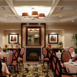 An elegant dining room setting with neatly arranged tables and chairs, featuring tasteful decor and warm lighting.