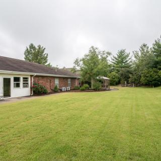 A view of a house with a spacious backyard and well-maintained lawn.
