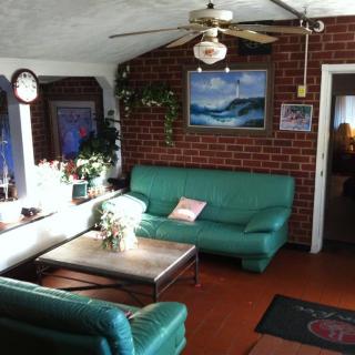 A cozy living room with green couches, a brick wall, and modern decor.