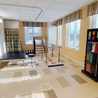 A rehabilitation room equipped with parallel bars and exercise tools for physical therapy.