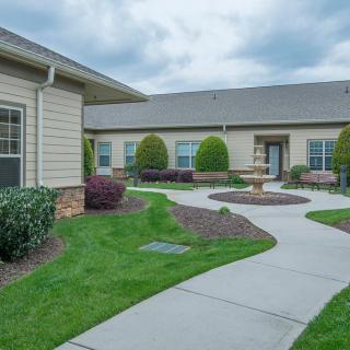 A landscaped courtyard with a winding pathway and well-maintained gardens in a residential setting.